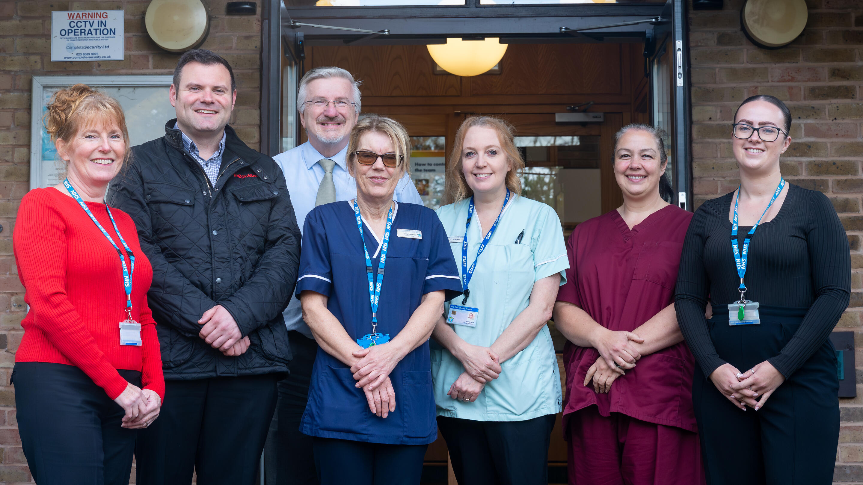 group of healthcare providers standing in front of building