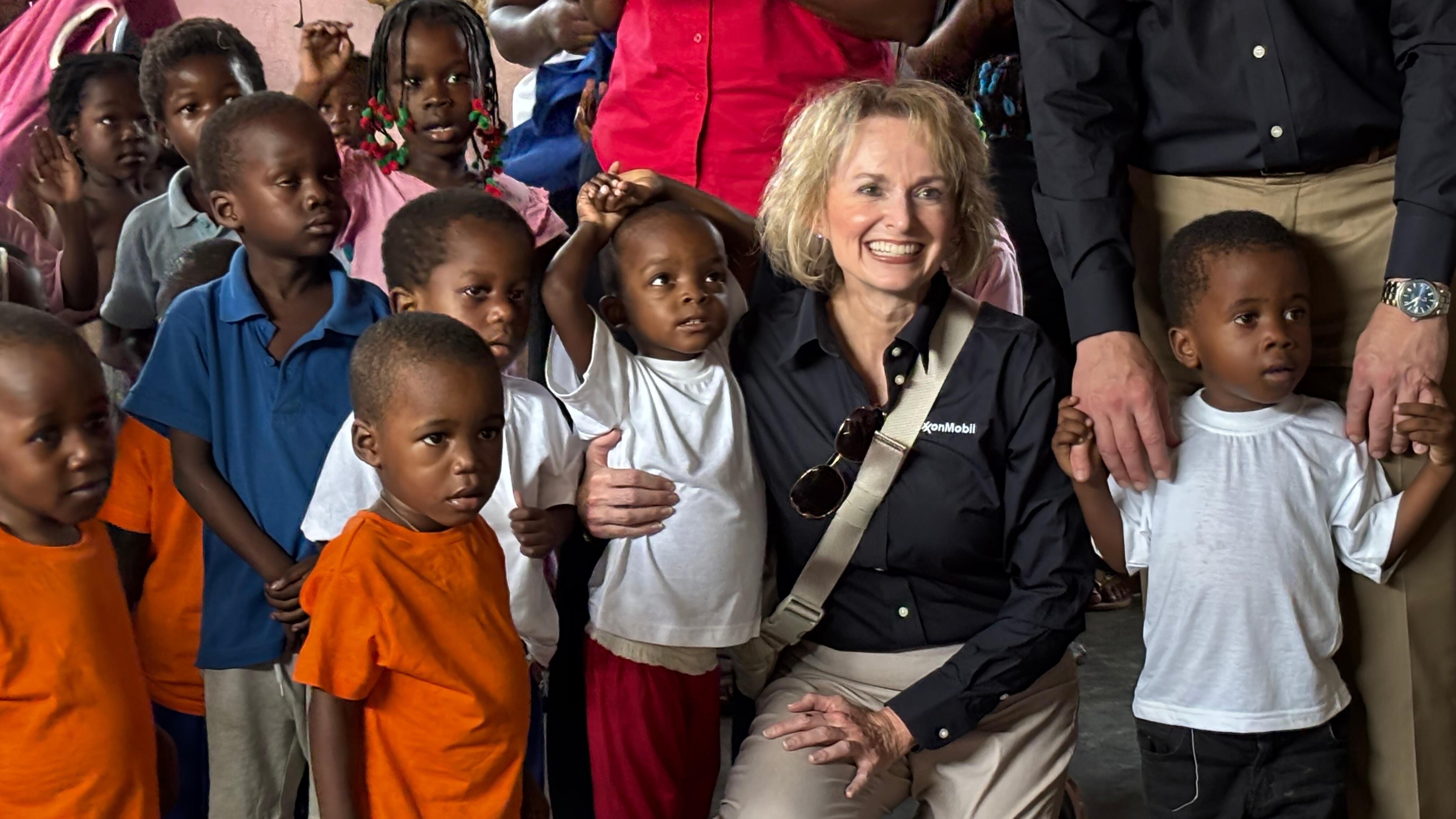 ExxonMobil's Head of Giving and Socioeconomics, Neely Nelson, with children at Sister Domingas & Friends' OCSI orphanage