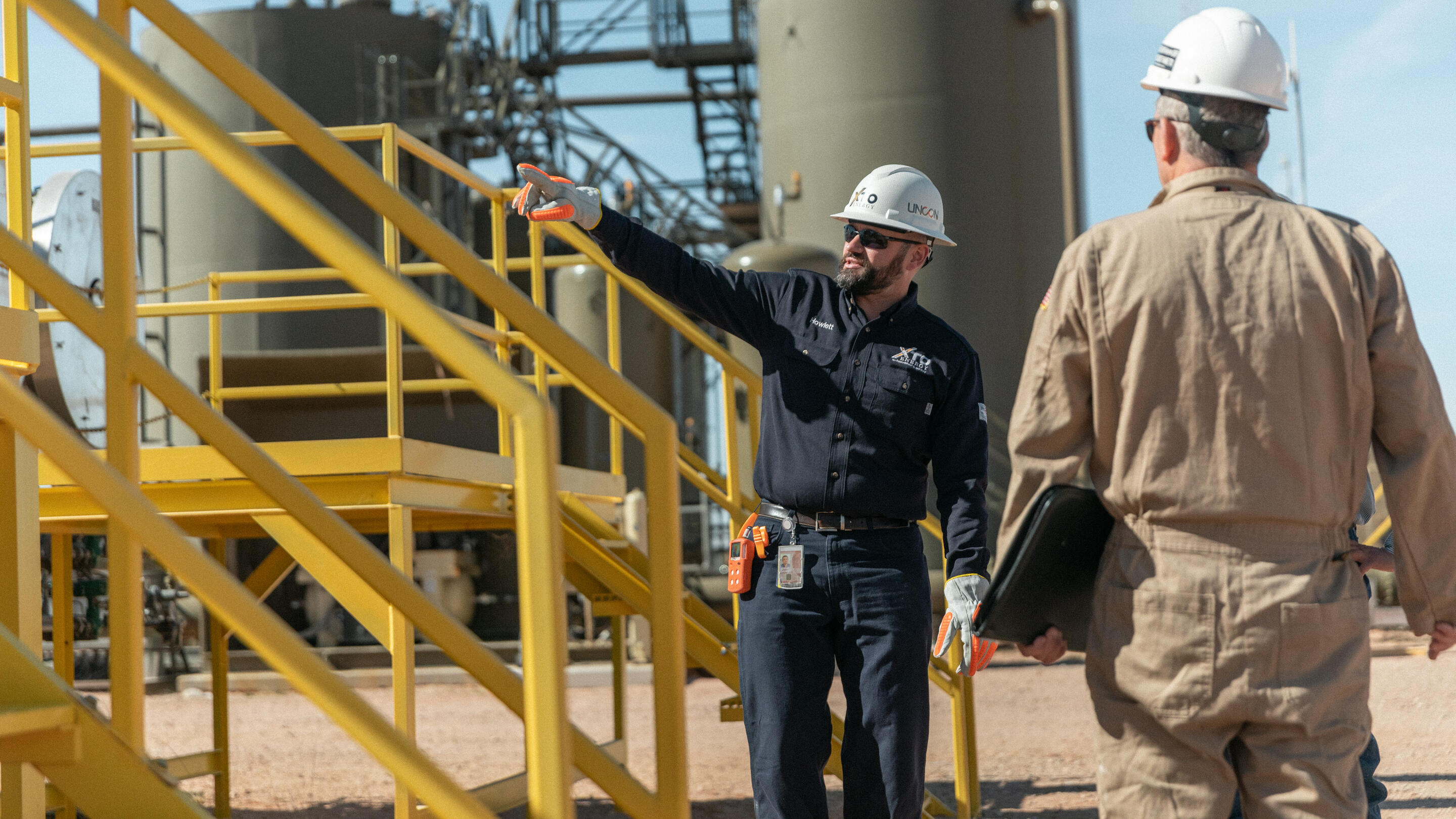 ExxonMobil employees working near oil and gas operations.