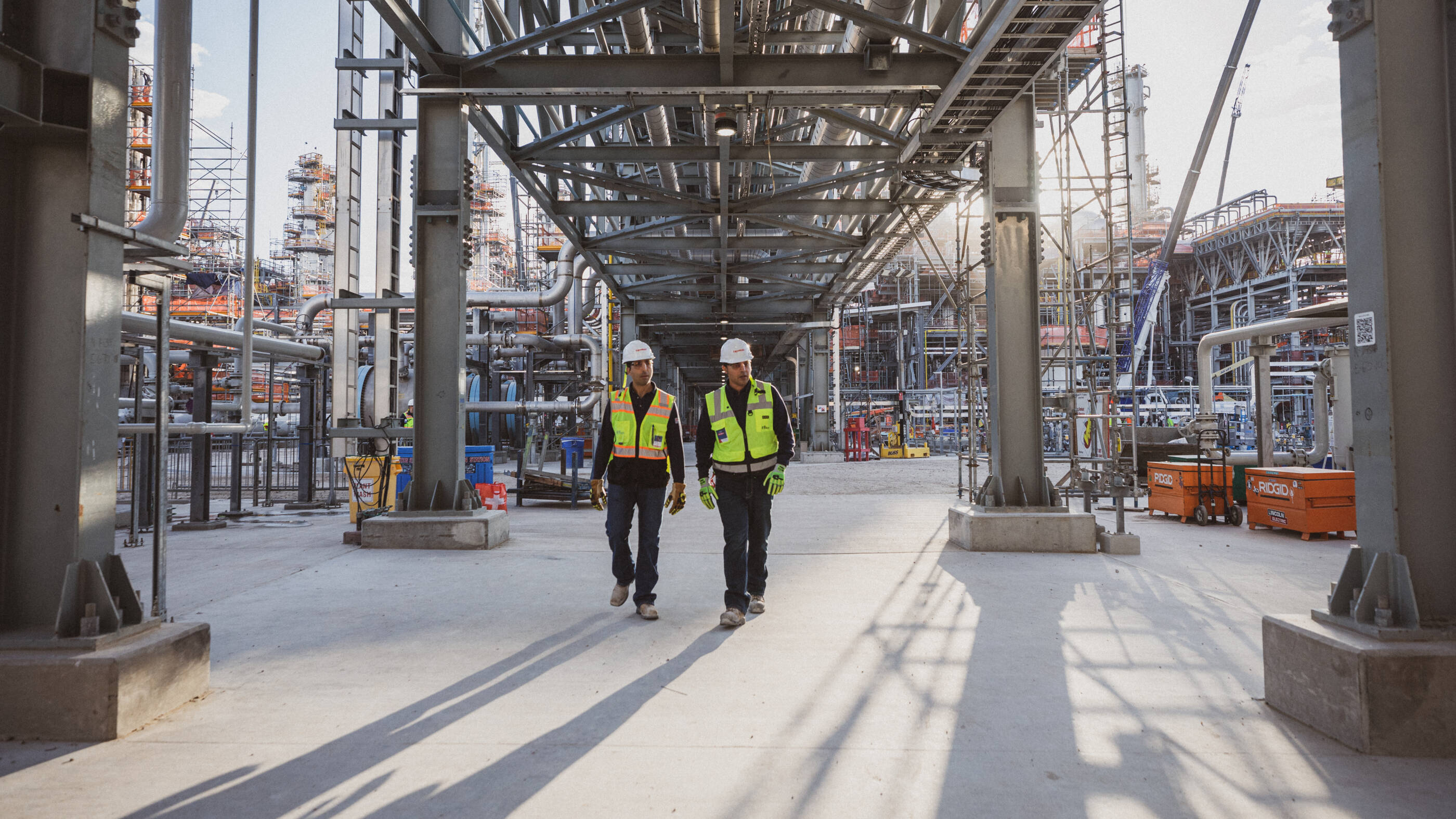 Two employees in safety equipment walking in the Baytown facility