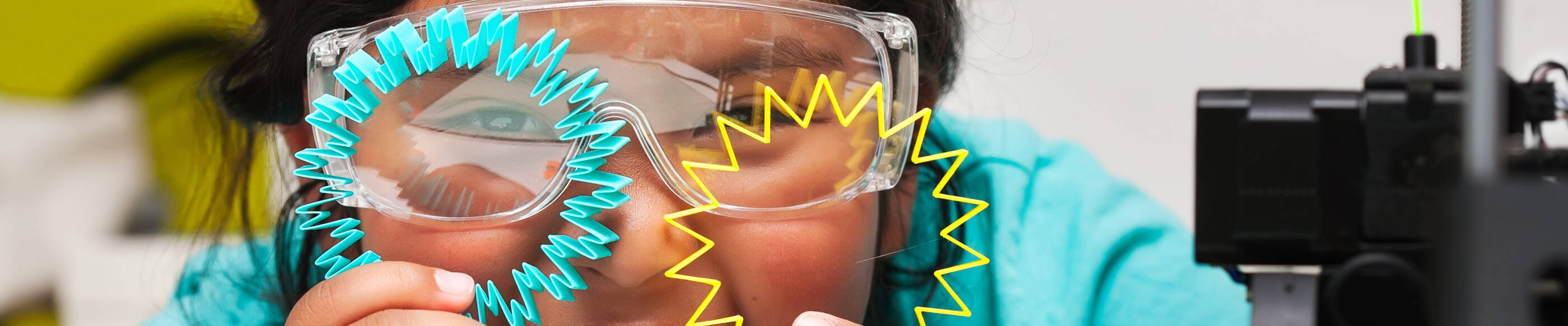 Happy STEM student smiles and shows off the colorful 3d printed shapes, plastic parts on the print bed with skirt for plate adhesion.