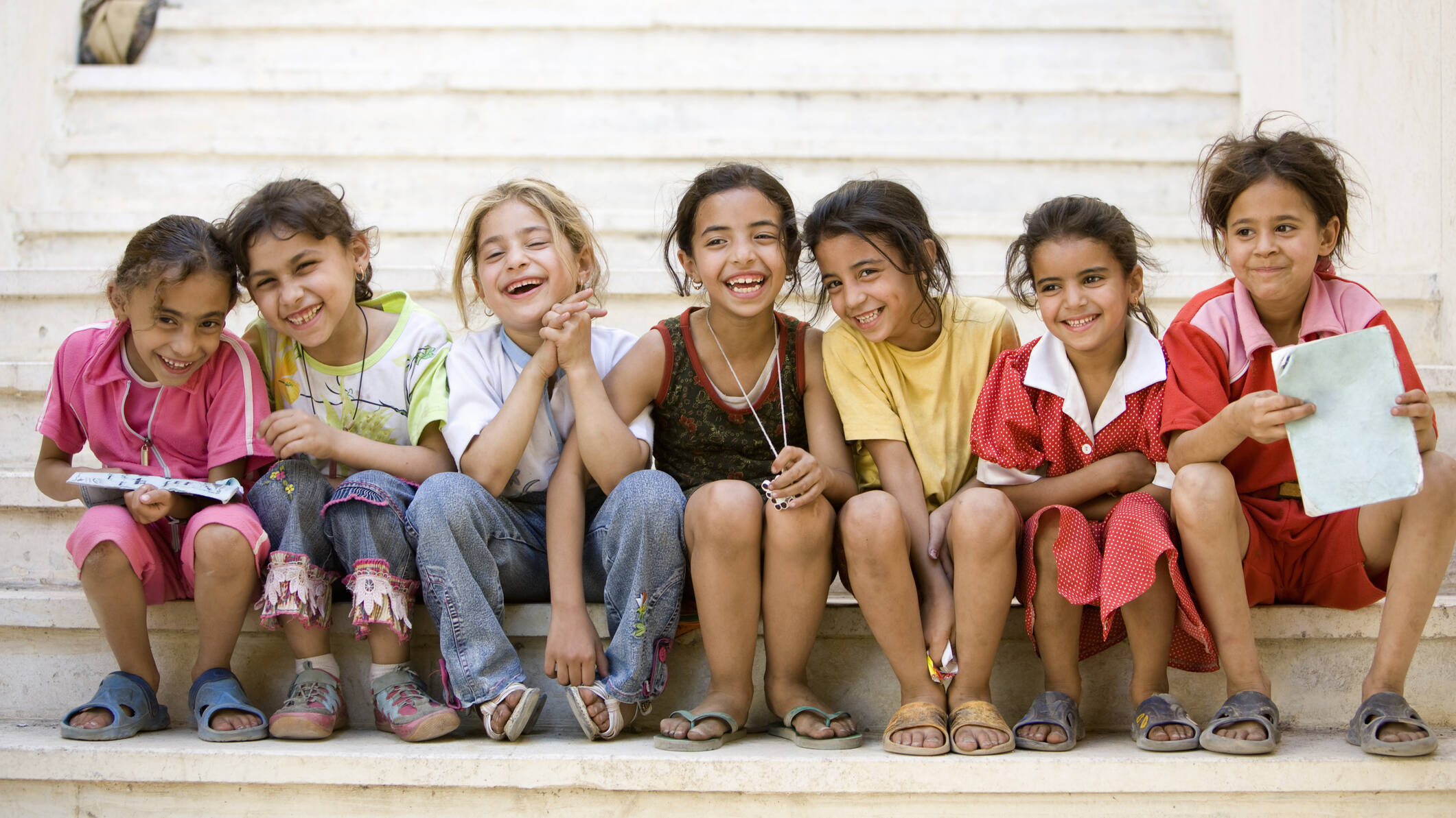 young middle eastern girls sitting on steps