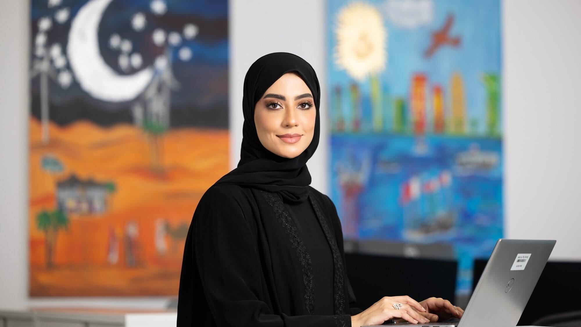 Noora Musa working on her laptop