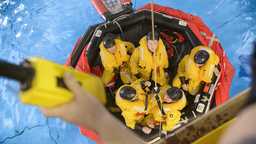 Oil workers learning survival skills in a pool